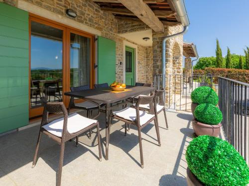 Donje BaredineにあるHoliday Home Istriana by Interhomeのバルコニーにテーブルと椅子が置かれたパティオ