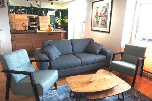 a living room with a couch and two chairs and a table at Atelier Achtung Ausblick! in Rendsburg