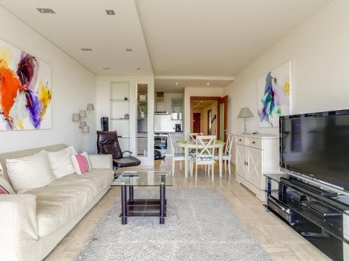 a living room with a couch and a tv at Apartment Le Roc by Interhome in Cannes