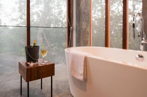 baño con bañera y mesa con copas de vino en Villa Amma Erna - Galle, en Galle