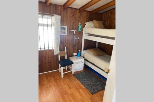 a room with two bunk beds and a chair at Refugio acogedor en Farellones in Santiago