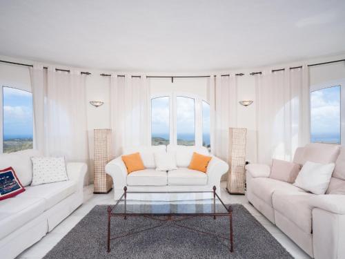 uma sala de estar com mobiliário branco e janelas grandes em Holiday Home Cielo Azul by Interhome em Benitachell