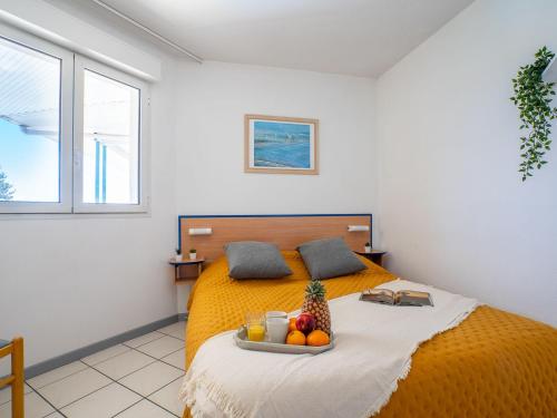 a bedroom with a bed with a tray of fruit on it at Apartment Golf de la Nivelle-4 by Interhome in Ciboure