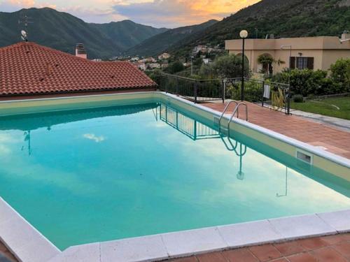 uma grande piscina azul com uma montanha ao fundo em Holiday Home Dada by Interhome em Boissano