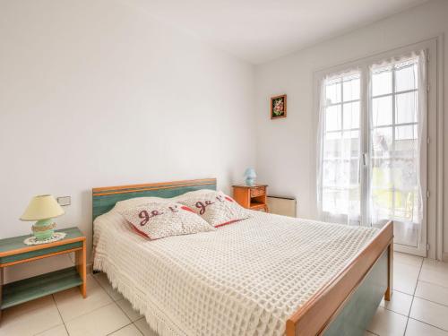 une chambre blanche avec un lit et une fenêtre dans l'établissement Holiday Home L'Albizia by Interhome, à Gujan-Mestras