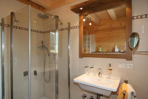 a bathroom with a shower and a sink and a mirror at Oberreitlehen in Bischofswiesen