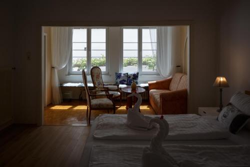 a bedroom with two swans on beds and a living room at Pension Laubenhof in Mörbisch am See