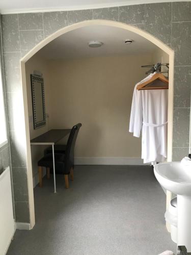 a bathroom with a table and a chair and a sink at The Oxfordshire in Blackpool