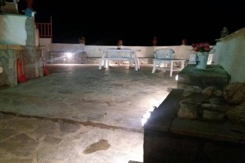 a patio with a table and two chairs at night at Villa Christina in Kithnos