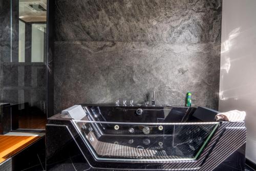 a bathroom with a black tub in a room at Little Suite in Halle an der Saale