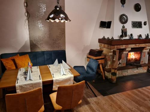 a dining room with a table and a fireplace at Zur Kringelwies in Masburg