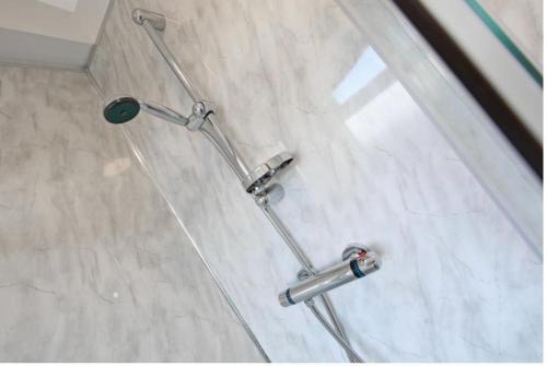 a shower in a bathroom with three chrome handles at 2B SPV Double En-suite Room in Wakefield