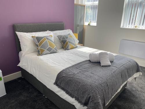 a bedroom with a large bed with white sheets and pillows at 2B SPV Double En-suite Room in Wakefield