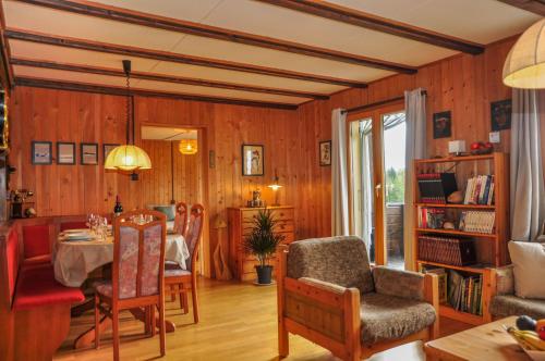 a living room with a table and a dining room at Chalet en pleine nature avec Spa in Le Locle