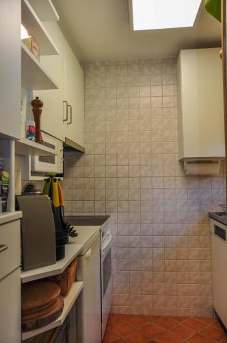 a kitchen with white appliances and a tile wall at Chalet en pleine nature avec Spa in Le Locle