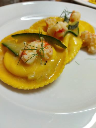 a plate of food with shrimp and vegetables on it at Hotel Regina in Caorle