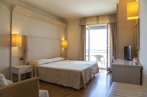 pokój hotelowy z łóżkiem i telewizorem w obiekcie Hotel Mara w mieście Ortona