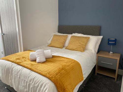 a bedroom with a bed with a yellow blanket at 2C SPV Double En-suite Room in Wakefield