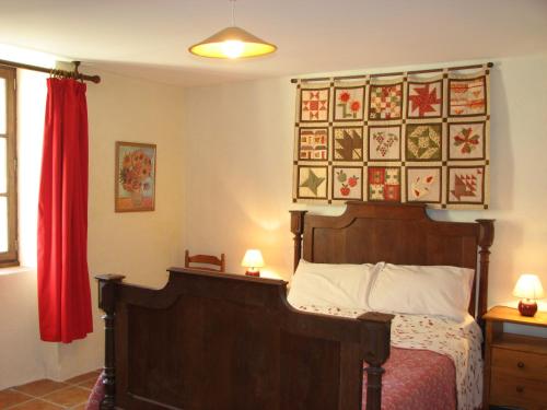 une chambre avec un lit et un rideau rouge dans l'établissement Limerac Cottage, à Salles-Lavalette