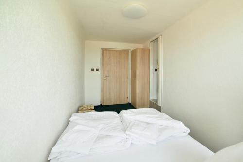 a bed in a room with white sheets at Pivovarský dvůr Lipan in Týn nad Vltavou