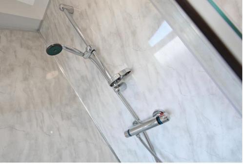 a shower in a bathroom with three chrome handles at 2D SPV Double En-suite Room in Wakefield