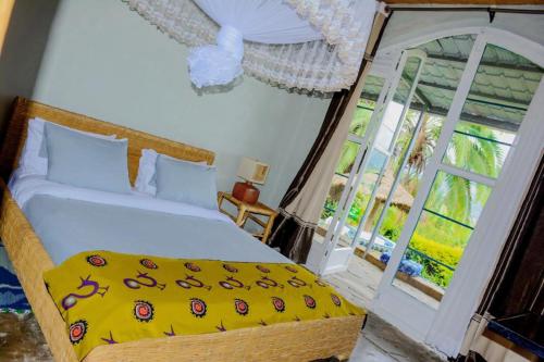 a bedroom with a bed and a large window at Palm Garden Resort in Gisenyi