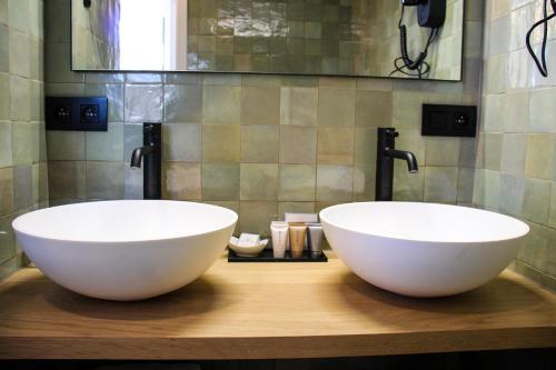 two white bowls on a wooden counter in a bathroom at B&B Villa Verde in De Haan