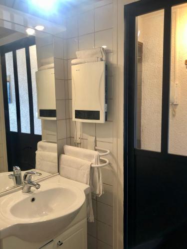 une salle de bain blanche avec un lavabo et un miroir dans l'établissement Studio lumineux neuf dans l'hyper centre avec vue, à Chamonix-Mont-Blanc