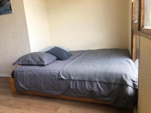 un lit avec des oreillers dessus dans une chambre dans l'établissement Studio lumineux neuf dans l'hyper centre avec vue, à Chamonix-Mont-Blanc