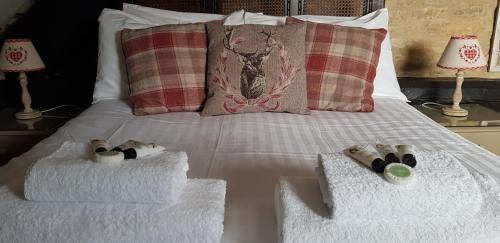 a bed with two towels and two shoes on it at The Kings Arms Hotel in Stow on the Wold
