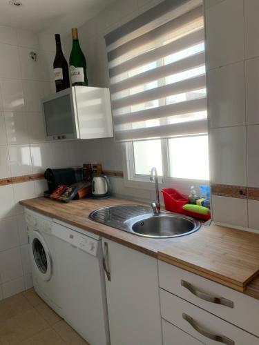 a kitchen with a sink and a washing machine at ATICO LA ILUSION CON PARkING in Sanlúcar de Barrameda