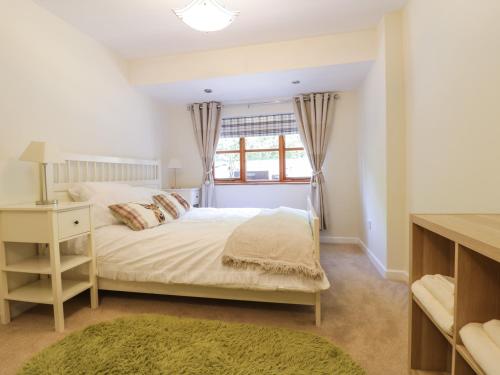 a bedroom with a bed and a window at Redwood Lodge in Wrexham