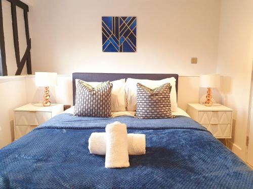 a bedroom with a blue bed with two lamps at Stansted Airport Luxury Apartment Bishops Stortford Millars One Loft 4 in Bishops Stortford