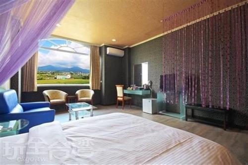een slaapkamer met een bed en een kamer met uitzicht bij 華秝茶油幸福莊園 in Puli