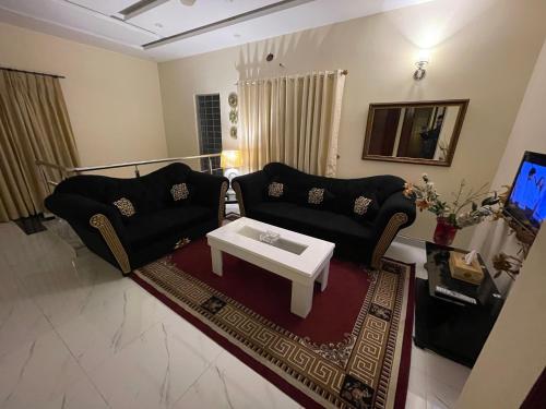 a living room with two couches and a coffee table at Divine Garden Lahore in Lahore