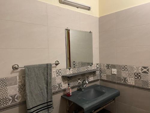 a bathroom with a green sink and a mirror at Lovely 1-Bed House in Lahore in Lahore