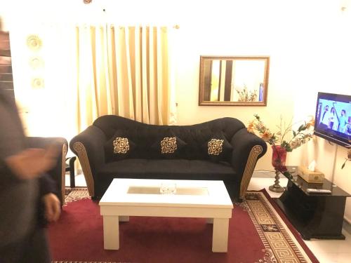 a living room with a couch and a coffee table at Divine Garden Lahore in Lahore