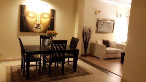 Un comedor con una mesa y sillas y un sofá. en Eden appartment in lahore, en Lahore
