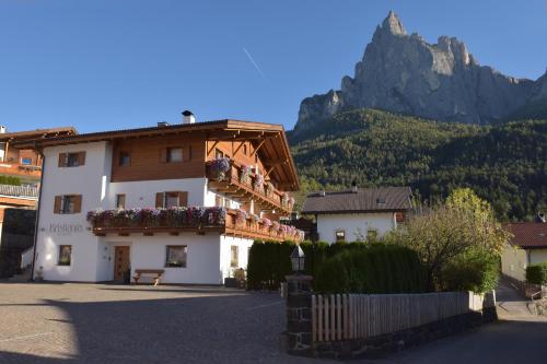 a building with flowers on it with a mountain in the background at Kristiania Apartement Typ A1 in Siusi