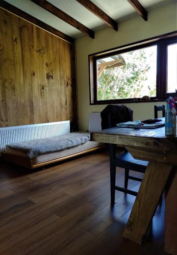 a room with a bed and a table and a window at CASA BARCA DE CHILOÉ in Castro