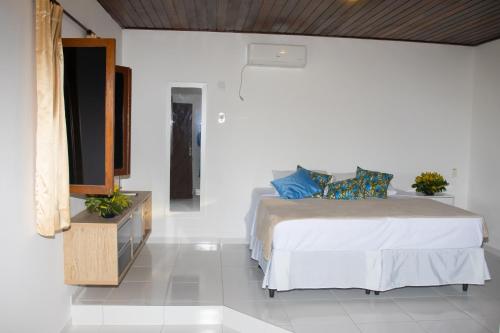 a bedroom with a bed and a dresser with a mirror at Pousada Cacimbinha - ePipa Hotéis in Pipa
