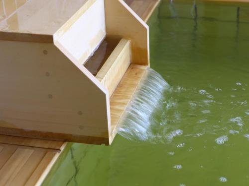 a pool of water with a wooden stairs in the water at Onyado Nono Kanazawa in Kanazawa