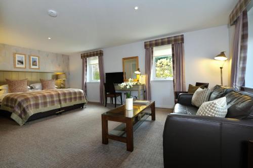 a hotel room with a bed and a couch at Sandown House in Nairn