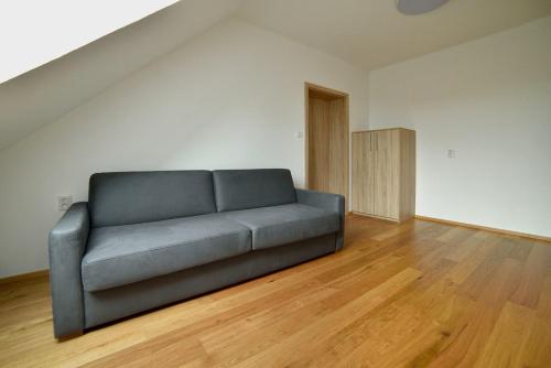 a couch in a living room with wooden floors at Pivovarský dvůr Lipan in Týn nad Vltavou