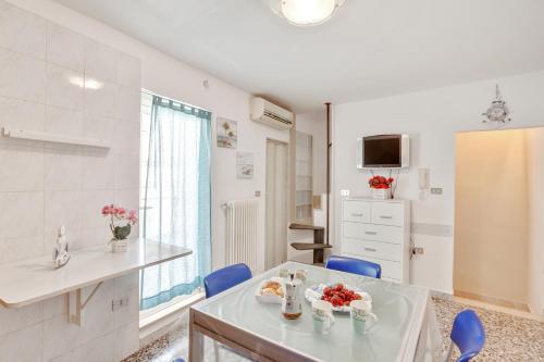 kuchnia ze stołem i niebieskimi krzesłami w pokoju w obiekcie Casa Alessandra Terrace Flat in Conversano w mieście Conversano