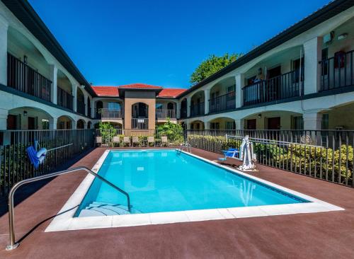 a swimming pool in front of a building at Red Roof Inn Orlando South - Florida Mall in Orlando