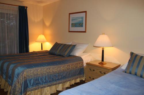 a hotel room with two beds and a lamp at Pensjonat Lazur in Mielno