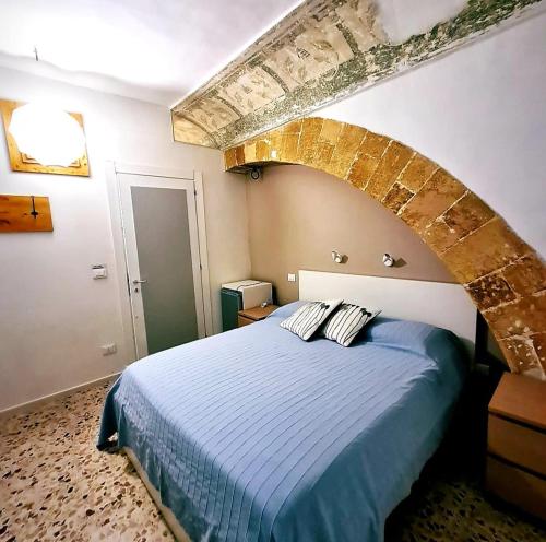 シラクーサにあるCasa vacanze Simopieroのレンガの壁のベッドルーム1室(青いベッド1台付)