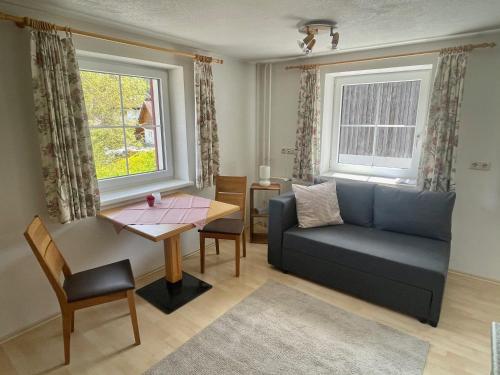 uma sala de estar com um sofá e uma mesa em Ferienwohnungen Haus Bergflora em Bach