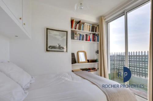 een witte slaapkamer met een bed en een raam bij DERNIER ETAGE TERRASSE Pte St Coud in Boulogne-Billancourt